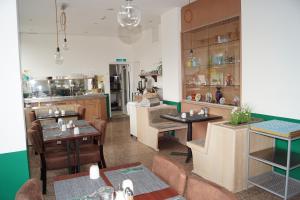 a restaurant with tables and chairs and a kitchen at Hotel Merian in Cologne