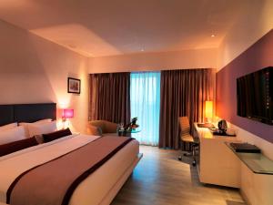 浦那Spree Shivai Hotel Pune的配有一张大床和一张书桌的酒店房间