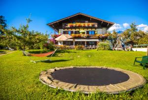 una casa con una cama elástica delante de ella en Oberstockinghof en Saalfelden am Steinernen Meer