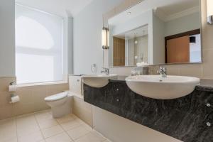 ダグラスにあるクレアモン ホテルのバスルーム(洗面台2台、トイレ、鏡付)