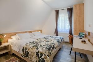 a bedroom with a bed and a desk and a laptop at The Starlings Apartments Plitvice Lakes in Plitvička Jezera