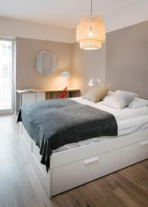 - une chambre avec un grand lit blanc et un bureau dans l'établissement TJB Design Apartment RAJSKA 8, à Gdańsk