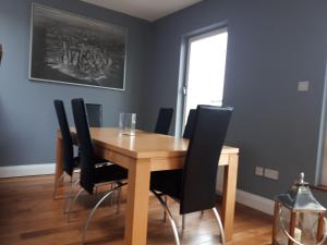 uma sala de jantar com uma mesa de madeira e cadeiras pretas em Luxurious Penthouse Apartment 1 , City Centre em Kilkenny