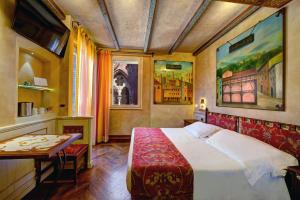 Art Hotel Commercianti في بولونيا: غرفة نوم فيها سرير وطاولة فيها