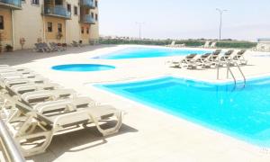 a pool with chaise lounge chairs and a resort at Like-Home-T1-Sun & Beach-Pools, AC in Ericeira