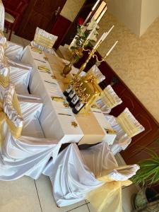 a long table with white and gold items on it at Hotel Elena in Veliko Tŭrnovo