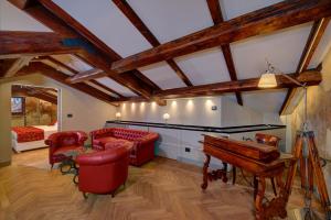 un soggiorno con sedie rosse e un pianoforte di Art Hotel Commercianti a Bologna