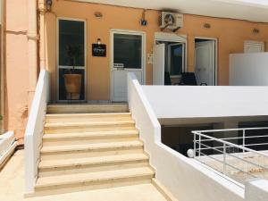 eine Treppe, die zum Eingang eines Gebäudes führt in der Unterkunft Korona beach apartments IIIΙ in Rethymno