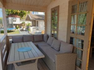 a patio with a couch and a table on a porch at Domki w Charzy pod Kotwica - Charzykowy in Charzykowy