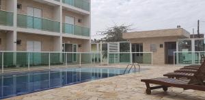 a swimming pool in front of a building at Pousada Femcut in Itanhaém