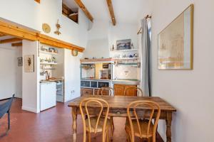 a kitchen with a wooden table and chairs at Le Central par Dodo-a-Cassis in Cassis