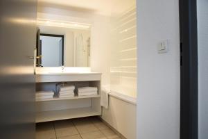 a bathroom with a sink and a mirror at Comfort Aparthotel Divonne La Versoix in Divonne-les-Bains +53 photos