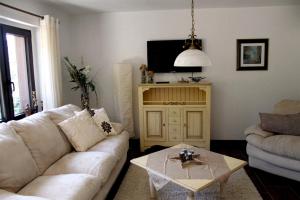 a living room with a white couch and a table at Ferienhaus Buschmann in Neustadt in Sachsen