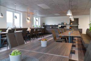 a dining room with wooden tables and chairs at Hotel Schlafplatz in Rodgau