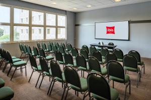 una sala de conferencias con sillas verdes y una pantalla en ibis Sao Jose do Rio Preto, en São José do Rio Preto