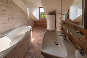 a large bathroom with a tub and a sink at Residence Tvrz Skočice in Skočice