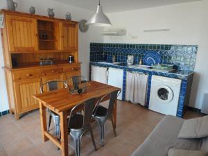 eine Küche mit einem Holztisch, Stühlen und einem Waschbecken in der Unterkunft Villa Via serena in Ajaccio