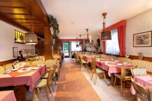a restaurant with tables and chairs with pink tablecloths at Hotel Silberdistel in Hinterzarten