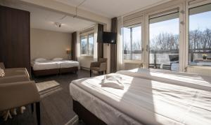 a hotel room with two beds and a window at Fletcher Hotel Landgoed Avegoor in Ellecom
