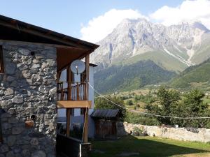 a building with a balcony with mountains in the background at Guest House Murkvam in Tvebishi