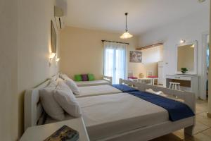 a large bedroom with two beds and a table at Angelika in Stoupa