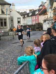 um grupo de pessoas a ver um homem a correr uma corrida em Forth Reflections Self Catering em Queensferry