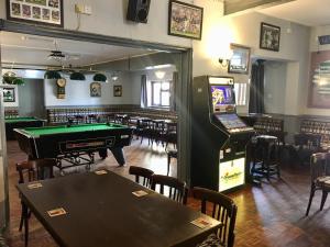 a pub with a pool table and a arcade game at The Rathmore in Cambridge