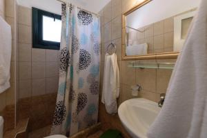 a bathroom with a shower curtain and a sink at Angelika in Stoupa