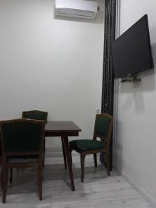 Zimmer mit einem Tisch, 2 Stühlen und einem TV in der Unterkunft Cosy Apartment in the Center in Tbilisi City