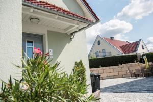 a white house with a flower in the yard at Ferienwohnung/Businessapartment in Wolframs-Eschenbach +2 photos