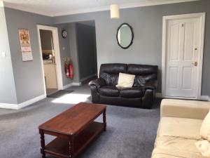 a living room with a leather couch and a coffee table at The Rathmore in Cambridge