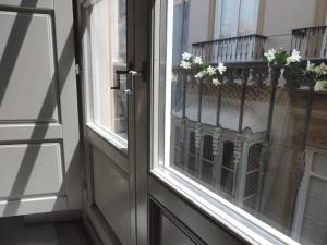 ein Fenster mit einem Balkon mit Blumen darauf in der Unterkunft Casita de Santos in Málaga