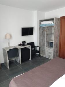 a bedroom with a desk and a television at Hotel Marblau Tossa in Tossa de Mar