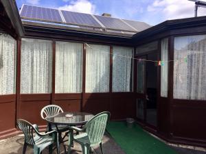 a patio with a table and chairs and solar panels at The Rathmore in Cambridge