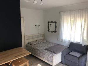 1 dormitorio pequeño con 1 cama y 1 silla en Apartments Nuna, en Krapinske Toplice