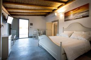 1 dormitorio con 1 cama grande y comedor en Le Finestre Su Porta Carrese - Luxury Rooms & Suites, en Matino