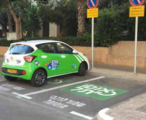 a small green and white car parked in a parking lot at Comfortable quiet room with a private bathroom in shared apartment in Tel Aviv