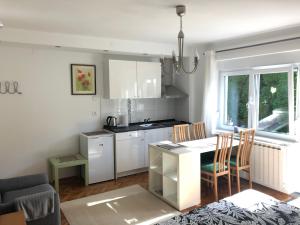 a kitchen with white cabinets and a table and chairs at Apartments Nuna in Krapinske Toplice