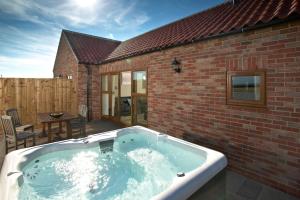 - un bain à remous dans l'arrière-cour d'un bâtiment en briques dans l'établissement Middleton Cottages, à Yarm