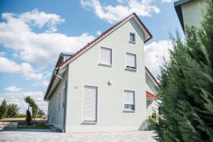 une maison blanche avec un toit rouge dans l'établissement Ferienwohnung/Businessapartment, à Wolframs-Eschenbach