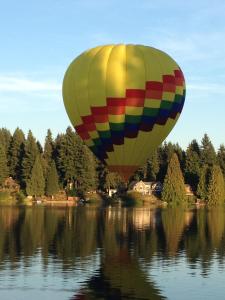 a colorful hot air balloon flying over a lake at Cottage Lake Bed and Breakfast in Woodinville