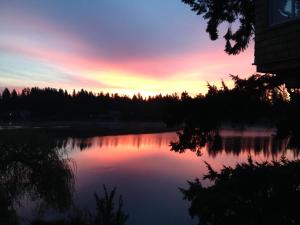 una puesta de sol sobre un cuerpo de agua en Cottage Lake Bed and Breakfast, en Woodinville