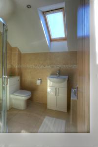 a bathroom with a toilet and a sink and a window at Middleton Cottages in Yarm