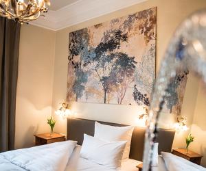 a bedroom with a bed and a painting on the wall at Hotel Ritzi in Munich +20 photos