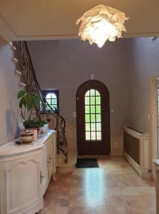 a large hallway with a door and a chandelier at Les Chambres de KERCHELGEN in Saint-Sauveur