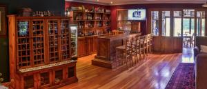 un bar in una stanza con mobili e sedie in legno di The FarSide Country Manor a Nottingham Road Altre 20 foto