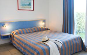 Cette chambre d'hôtel comprend un lit avec un chapeau. dans l'établissement Résidence Odalys Le Village des Amareyeurs, au Château-dʼOléron