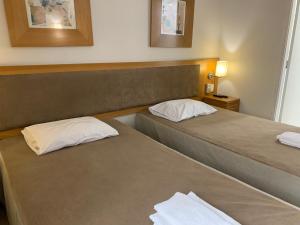 2 camas en una habitación de hotel con 2 camas en CHARMOSO FLAT NA OSCAR FREIRE, en São Paulo