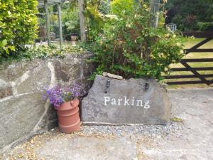 a sign that says parking next to a pot with flowers at Mill Cottage in Llanddeiniol