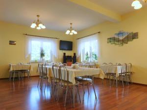 une salle de conférence avec des tables, des chaises et une télévision dans l'établissement Willa na Stoku, à Krynica-Zdrój